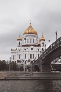 View of arch bridge over river against buildings