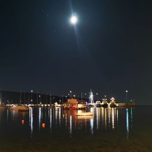 Illuminated sea against sky at night