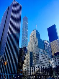 Low angle view of skyscrapers against clear blue sky