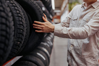 Man customer choosing new tires in the supermarket. auto shop with car goods.