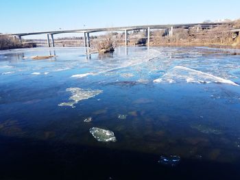 Frozen lake against clear blue sky