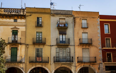 Facade of colorful historical buildings on a narrow street in the old town of barcelona, spain.