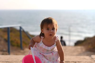 Portrait of cute girl at beach against sky