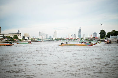 Boats in river with buildings in background