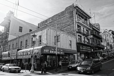 Traffic on city street by buildings against sky