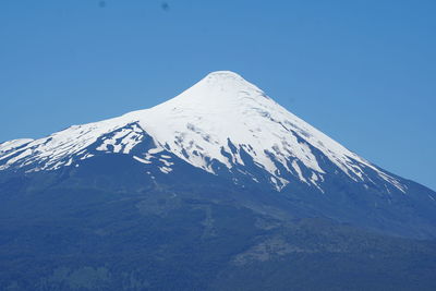 Scenic view of snowcapped mountains against clear blue sky