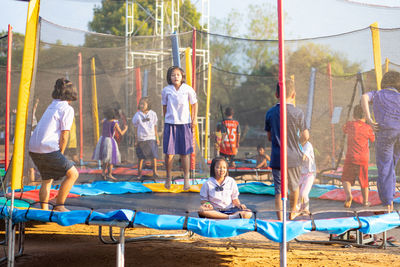 Children playing on playground against building