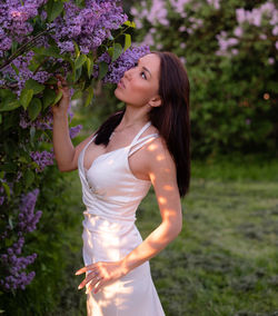 Beautiful woman standing by flowering plants