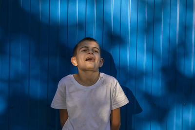 Speechless marvel, boy in surprise captured against vibrant blue background