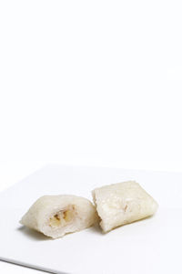 Close-up of bread in plate against white background