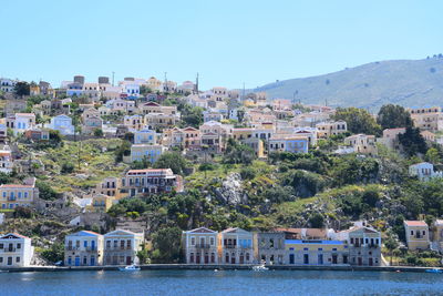 Residential district by sea against clear sky