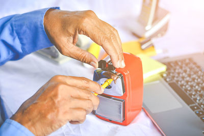 Cropped hands of businessman using pencil sharpener