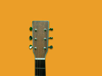 Close-up of guitar against yellow background