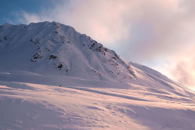 Scenic view of snow covered mountains against sky during sunset