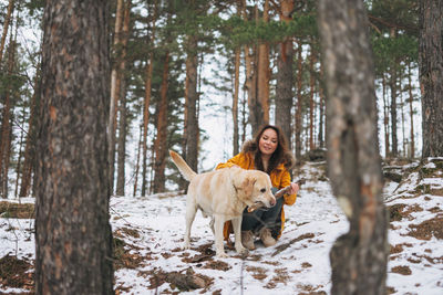 Woman with dog in forest during winter