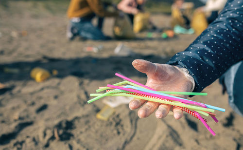 Close-up of hand holding multi colored straws