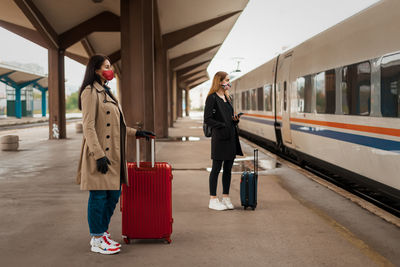 Full length of woman standing on train at railroad station