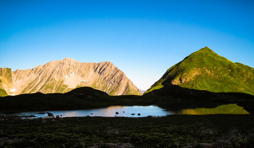 Scenic view of mountains against clear blue sky