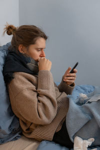 Young girl feeling sick, suffering from rhinitis or allergy. woman hold in hand phone. paper napkin