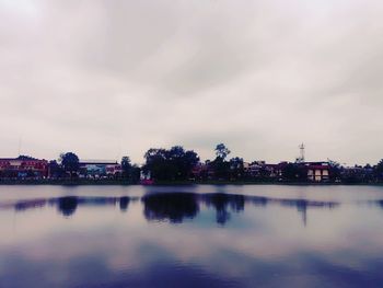 Scenic view of river by city against sky