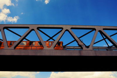 Low angle view of train on railway bridge against sky