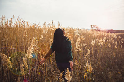 Woman standing on field against sky