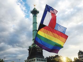 Low angle view of flags against cloudy sky