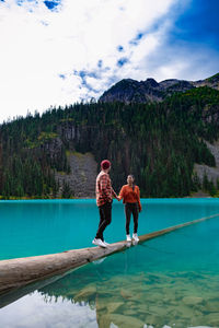 Full length of friends on mountain against sky