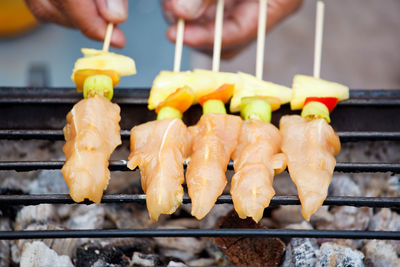 Close-up of person preparing food on barbecue grill