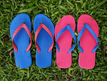 Photo of colorful rubber slippers or flip flops on fresh green grass