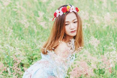 Woman wearing tiara while sitting on field