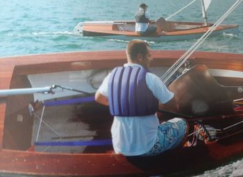 Rear view of men sitting on boat