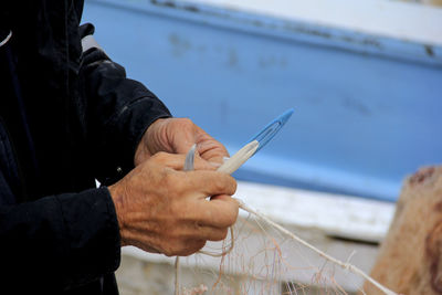 Fisherman repairing fishing net