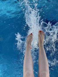 Low section of person feet in swimming pool