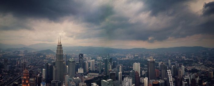 View of cityscape against cloudy sky