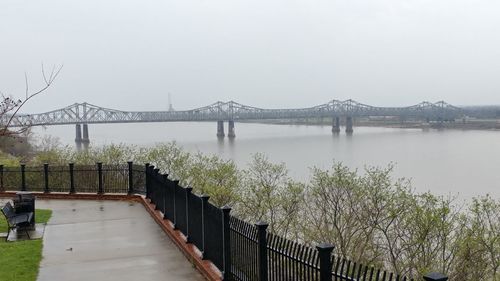 Bridge over river in city against clear sky