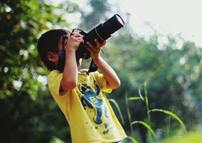 Boy photographing with digital camera
