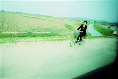 Man riding bicycle on field