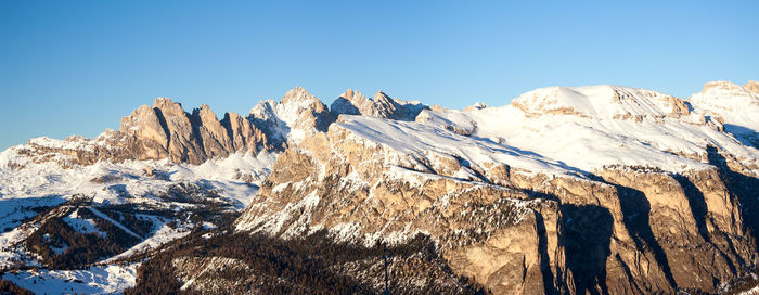 Panoramic view of snowcapped mountains against clear blue sky