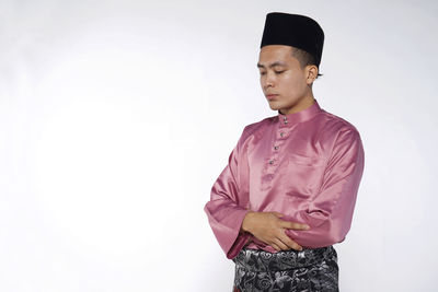 Young man looking away against white background