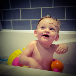 Portrait of cute baby boy in bathroom