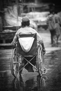 Rear view of man sitting on street