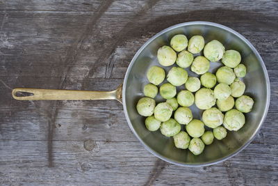 High angle view of brussels sprouts in container on wooden table