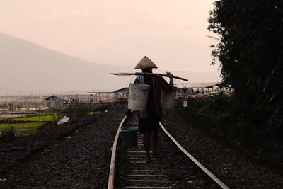 Man standing on railroad track against sky