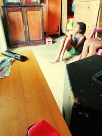 High angle view of woman sitting on table at home