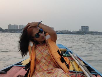 Portrait of young woman holding boat in sea