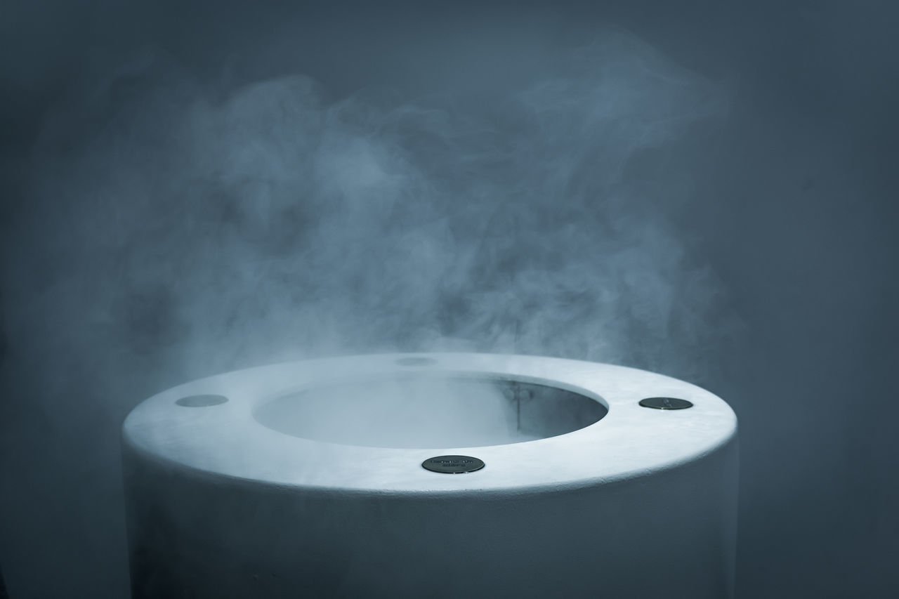 smoke - physical structure, indoors, no people, close-up, technology, focus on foreground, still life, metal, steam, heat - temperature, white color, fuel and power generation, studio shot, container, social issues, communication, domestic room, connection, black background, electricity, pollution