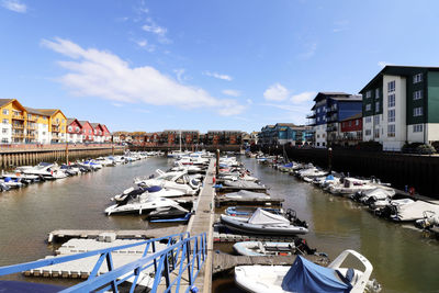 Boats moored in harbor by buildings in city