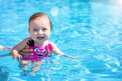 Portrait of cute baby girl in swimming pool