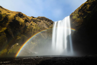 Scenic skogafoss waterfall with rainbow on a calm bright day in iceland